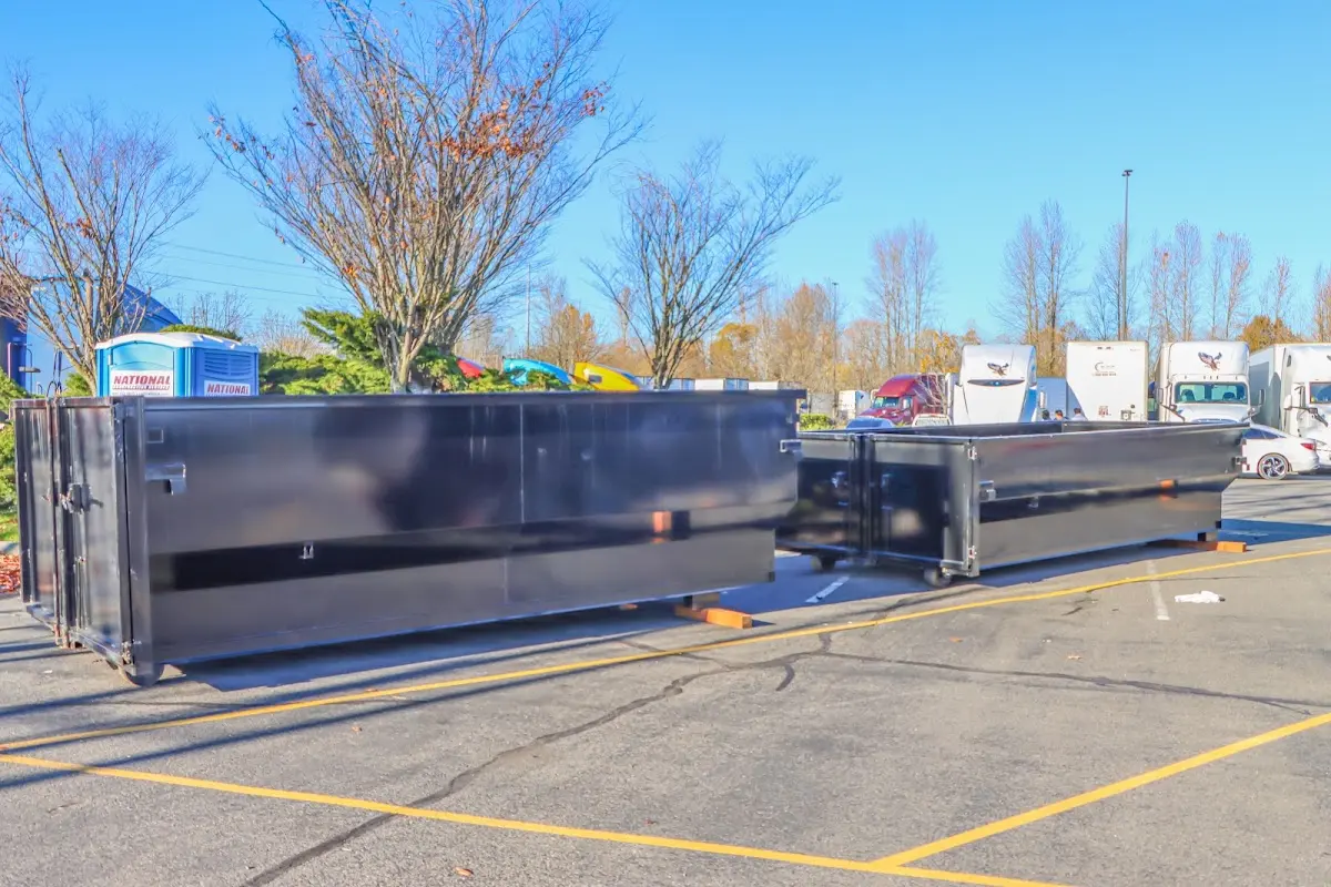 Professional dumpster rental service with roll-off container on residential driveway in East Greenwich